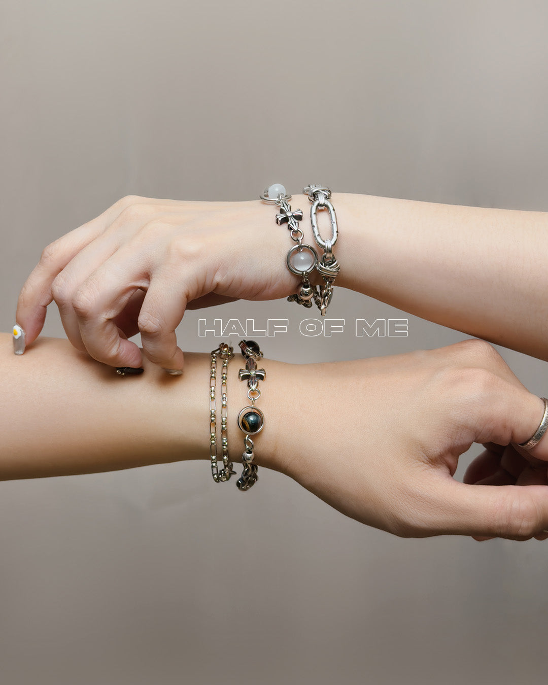 BLFX Half of me Two wrists with silver bracelets on a neutral background