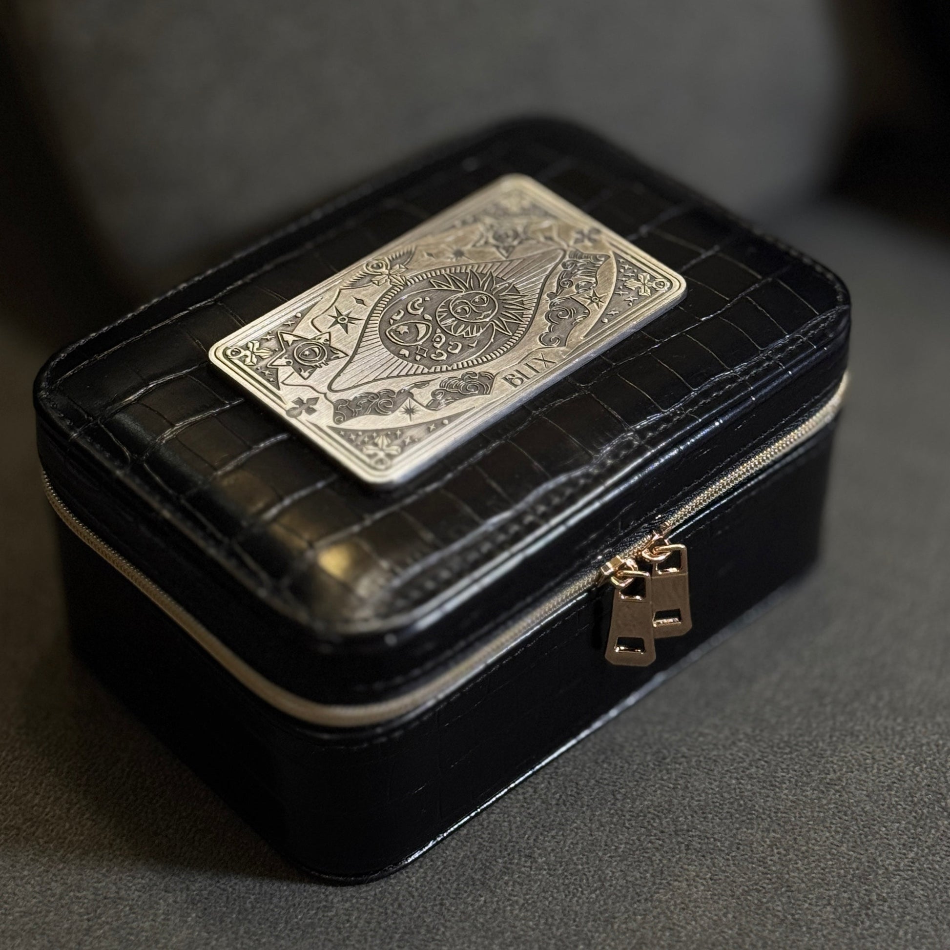 Black jewelry box with a playing card design on a gray background